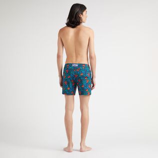 Kurze Tropical Flowers Stretch-Badeshorts mit flachem Bund für Herren Marineblau Rückansicht getragen