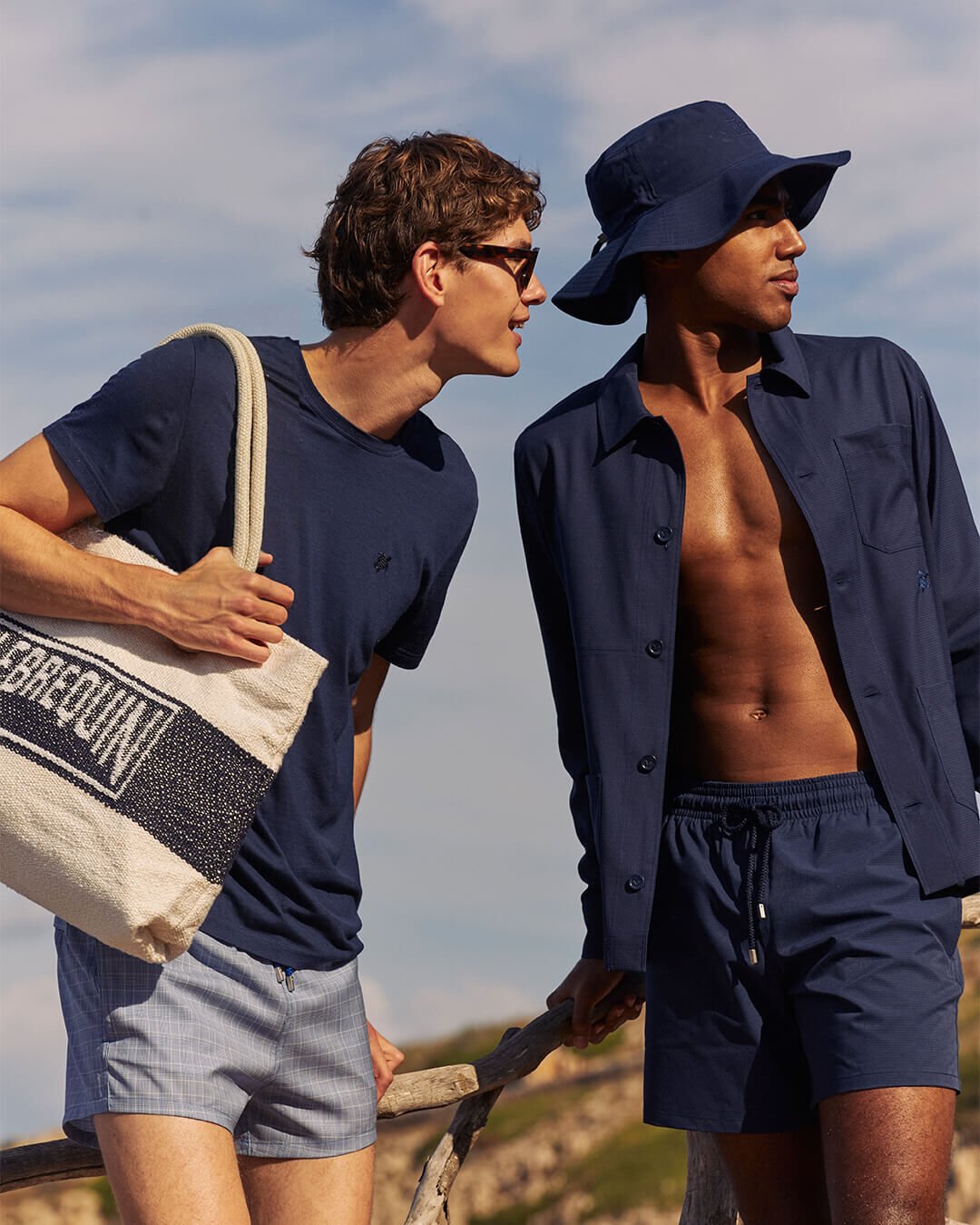 WOOL SWIM SUITS - VILEBREQUIN SUMMER 26 Two men pose outdoors in summer outfits.