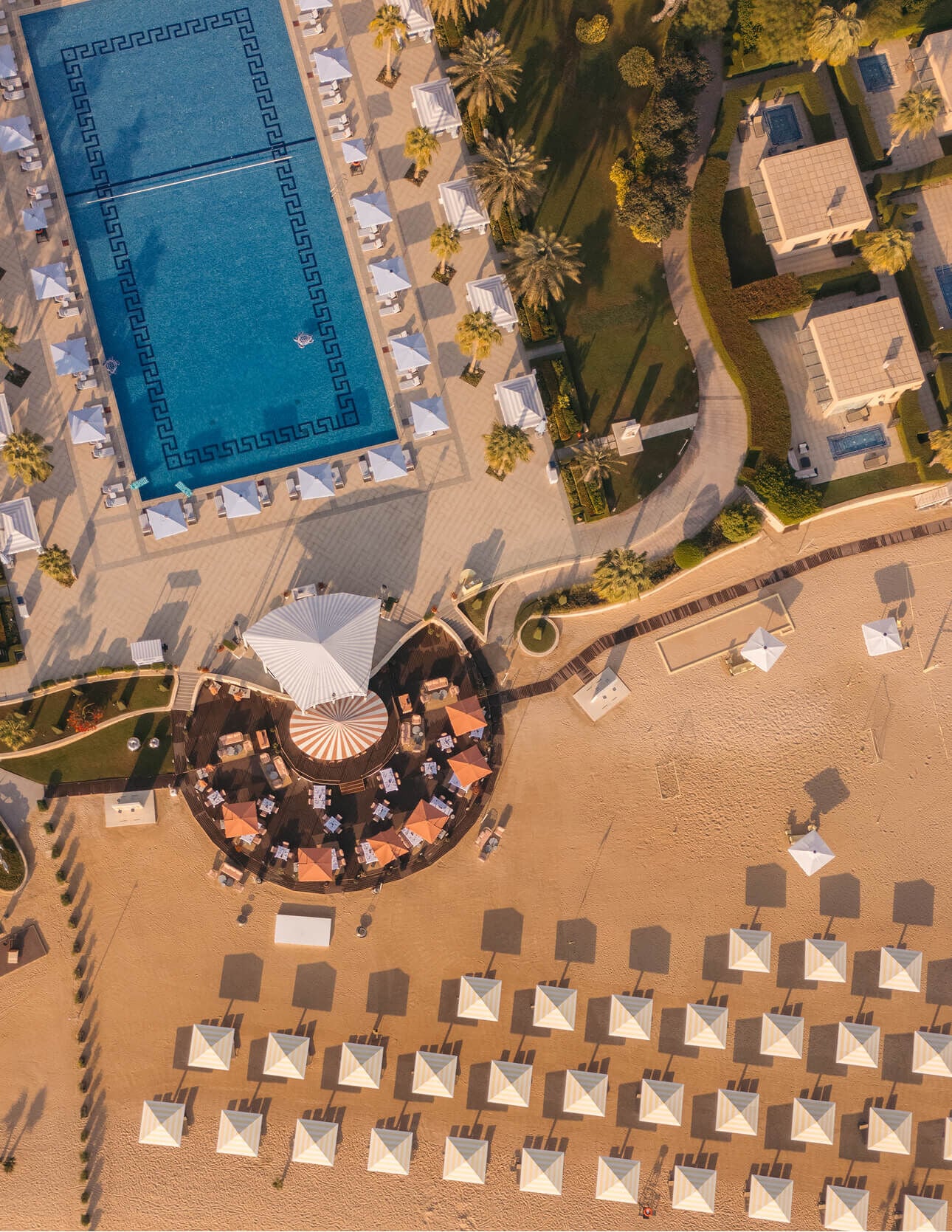 Aerial view of a beach with geometric umbrellas.