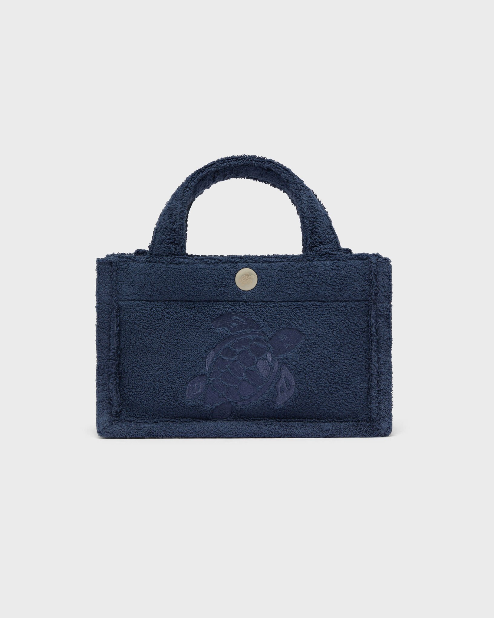 A small navy blue handbag with a textured, fluffy fabric and a turtle design embossed on the front.