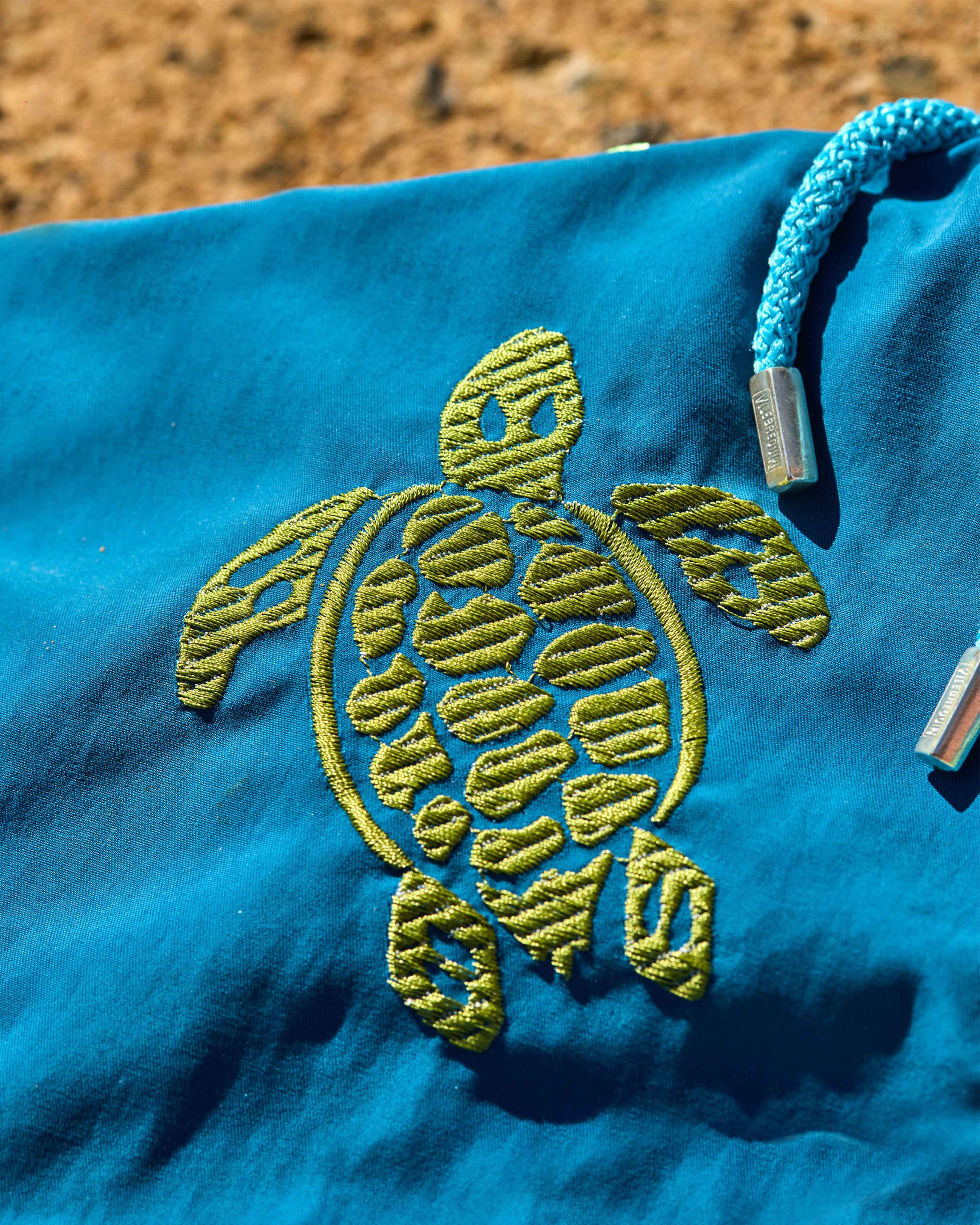 Short de bain brodé pour homme sur la plage