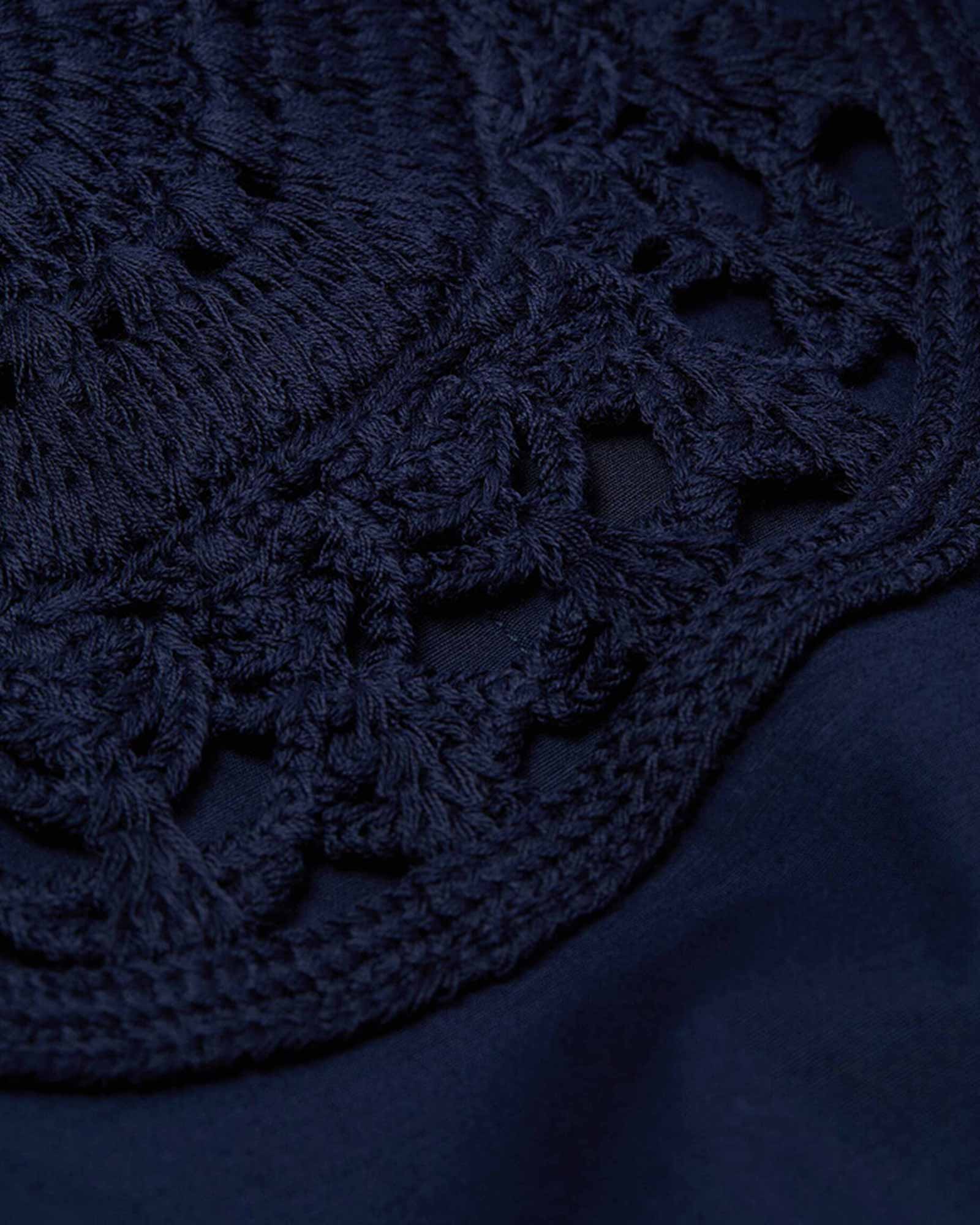Détail de crochet bleu marine sur tissu.   