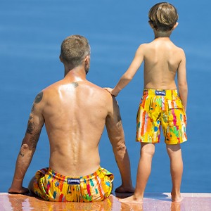 Father and son wearing matching swim shorts