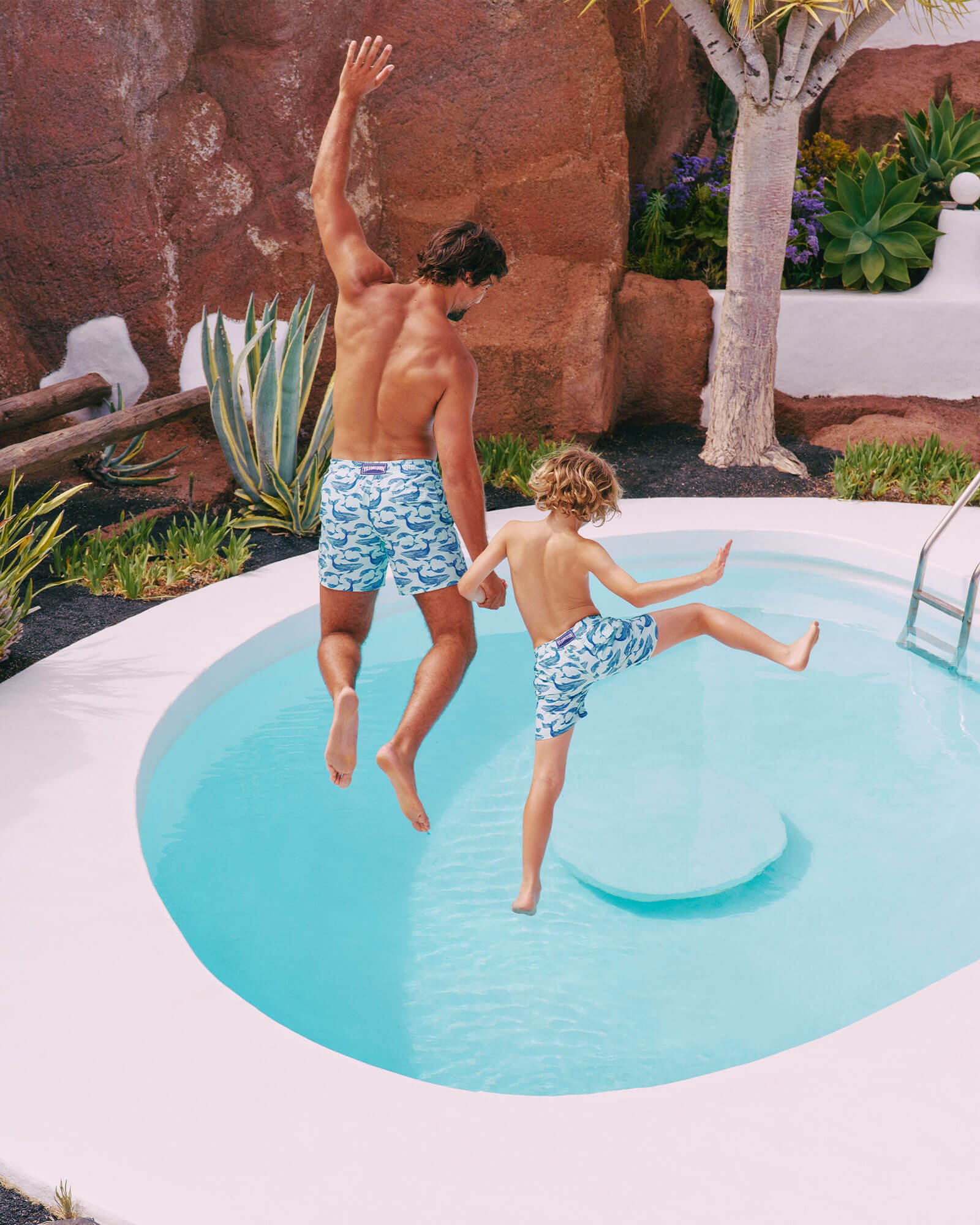 a father and his son in a swimming pool.