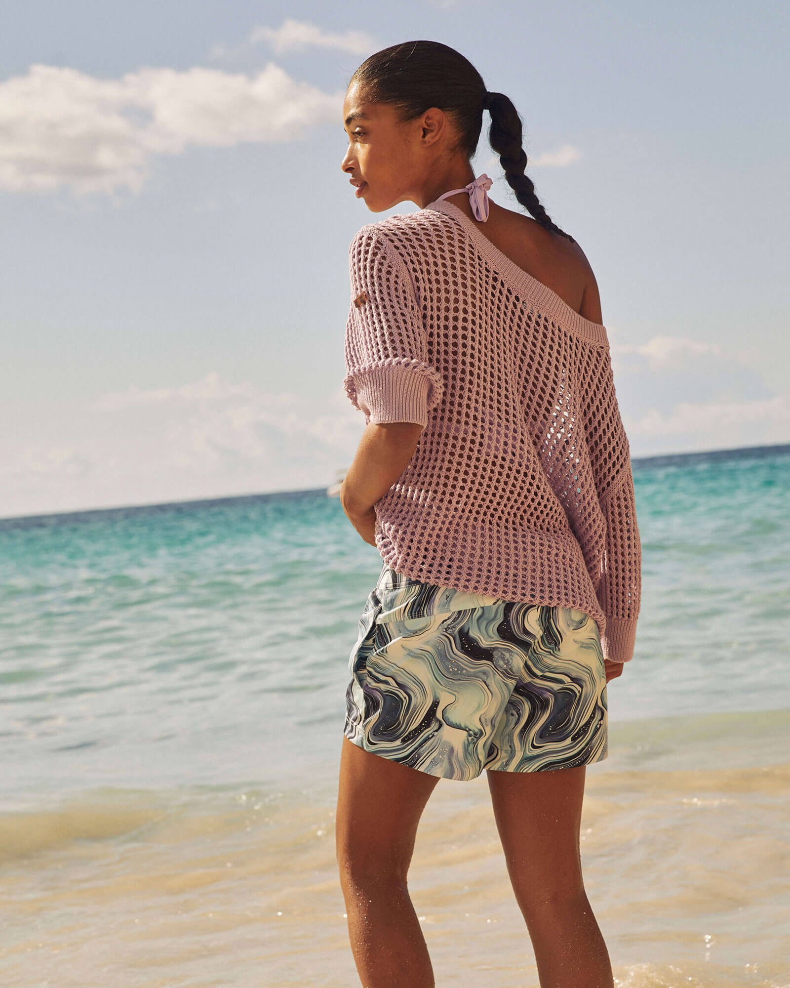 Eine Frau am Strand, die eine Badehose mit Marble-Print trägt