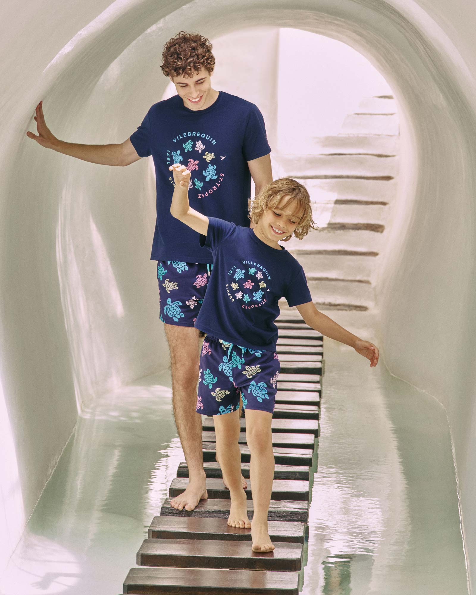 A man and his son wearing matching swim shorts