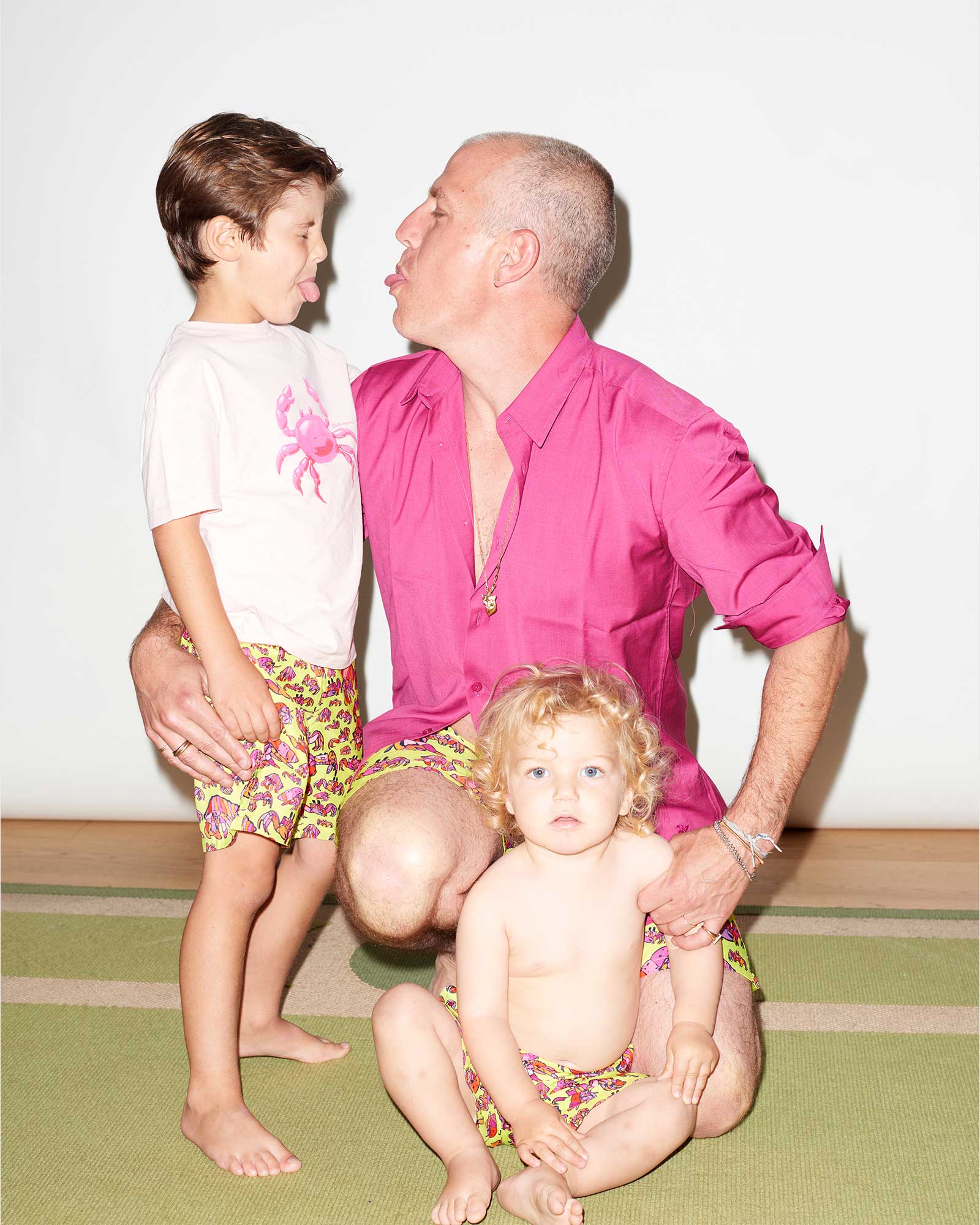 A father with his two sons wearing matching swim shorts