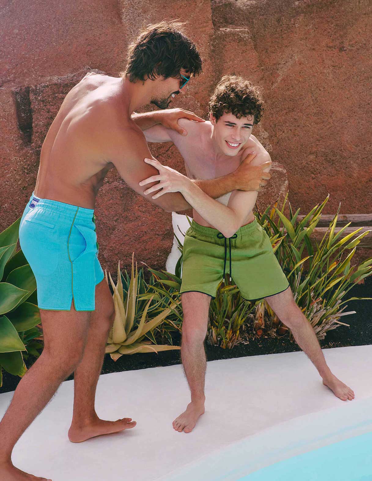 Deux hommes jouant au bord de la piscine