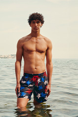  A man wearing a printed swim trunks on the beach