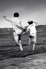  A picture of a father and a son jumping in the sea