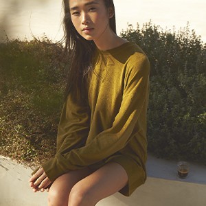 A woman wearing the unisex terry bowling shirt and the unisex terry bermuda solid