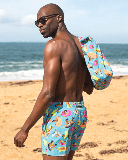 A man wearing a printed men’s swim trunks