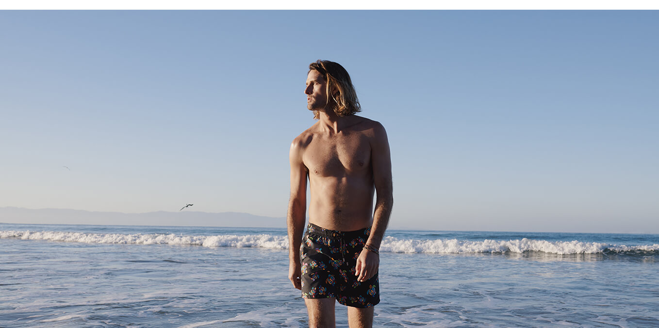 Man on the beach wearing a printed swim shorts
