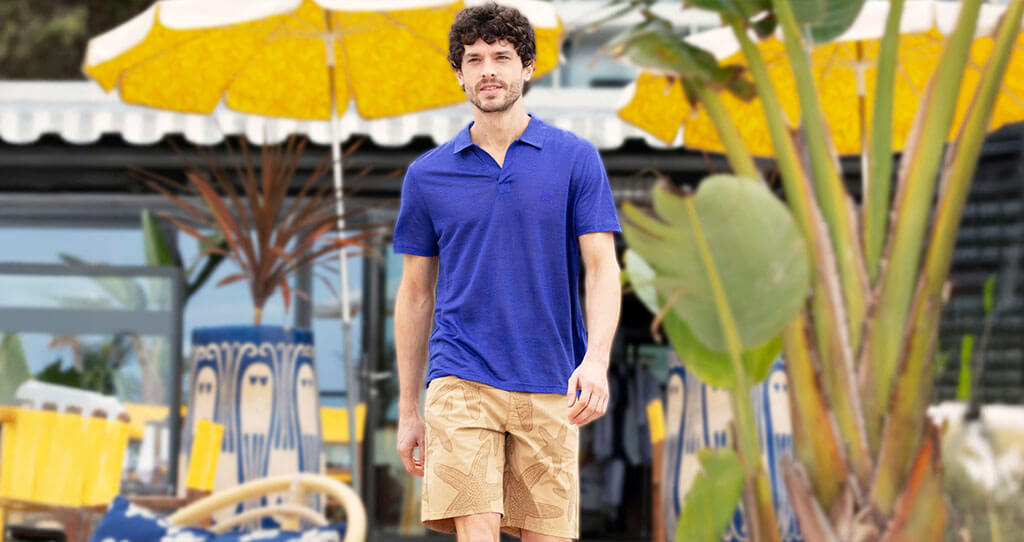 Four men wearing the Men Cotton Pique Polo Shirt Solid in tropezian green, poppy red, carrot and divine.