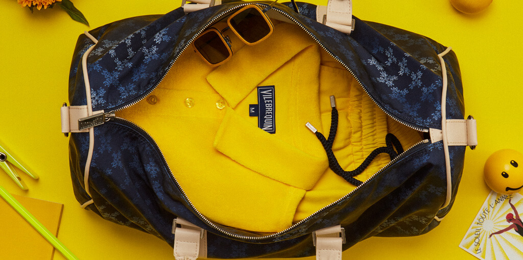 Yellow men’s polo and shorts in a women and men’s travel bag