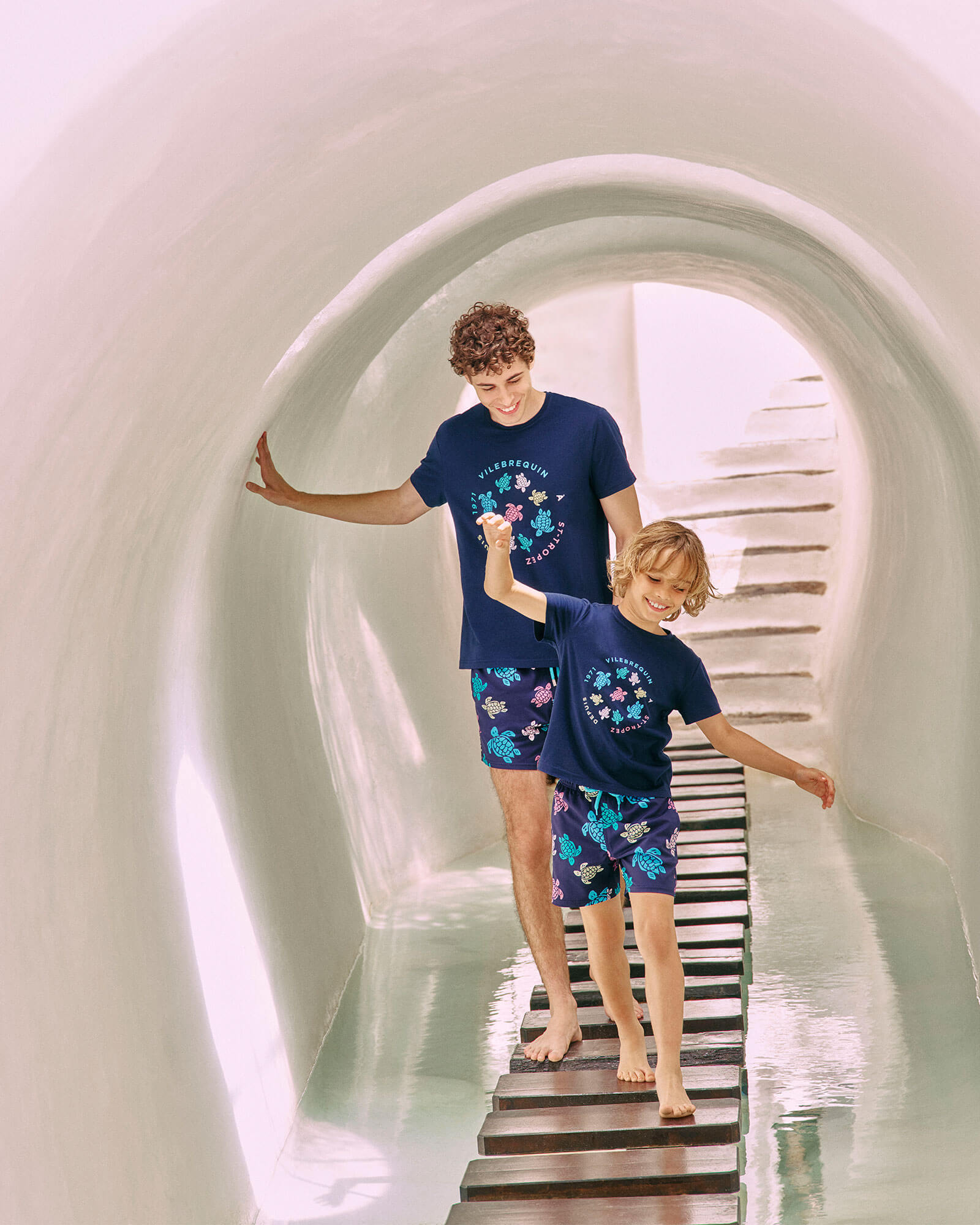 Ein Vater und sein Sohn, die beide die gleichen Badeshorts tragen