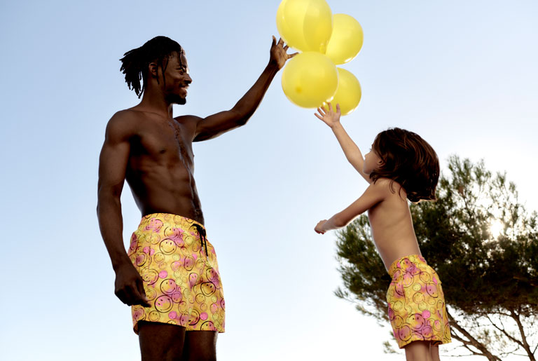 Father and son high fiving in swimsuits