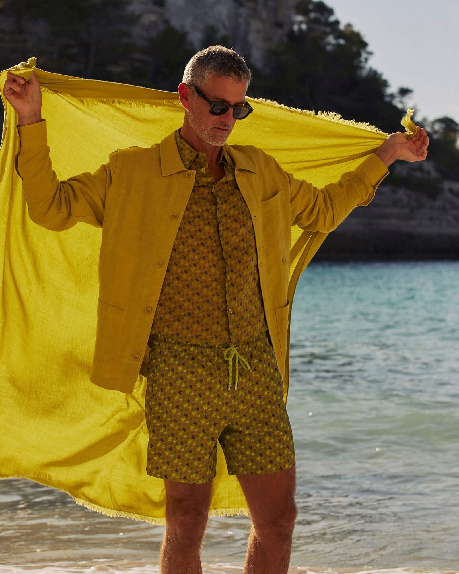 Ein Mann, der am Strand spazieren geht und dabei Kleidung von Vilebrequin trägt