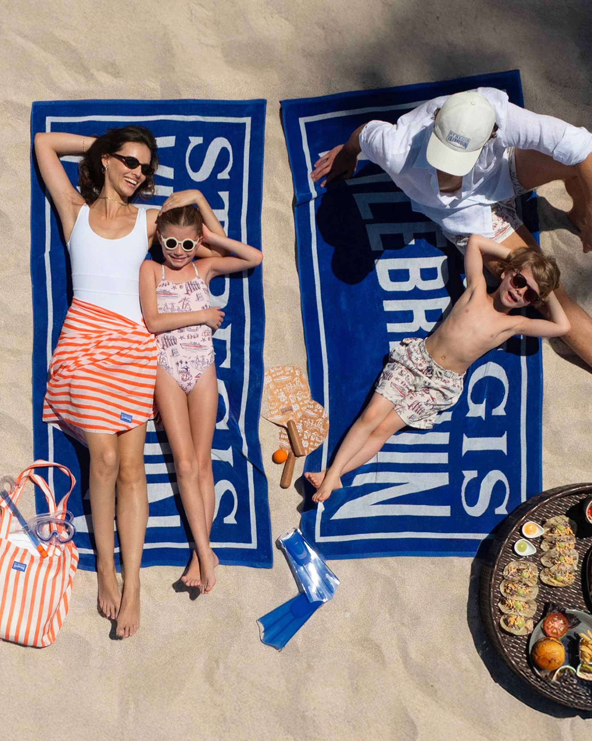 Family on the beach wearing swimsuits from the Saint Regis collaboration