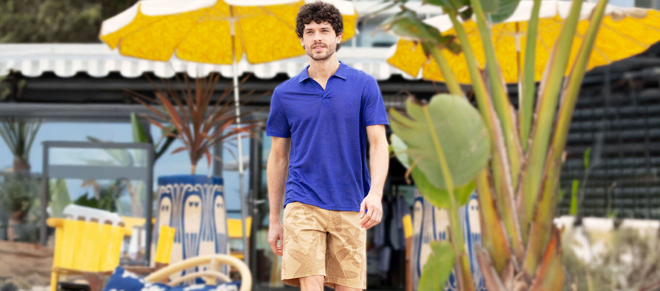 Four men wearing the Men Cotton Pique Polo Shirt Solid in tropezian green, poppy red, carrot and divine.