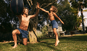 Father and Son high fiving wearing matching swimshorts