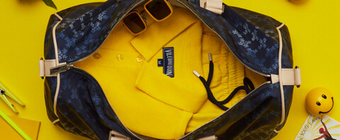 Polo y shorts amarillos de hombre en una bolsa de viaje para hombre y mujer