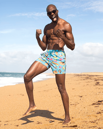 A man on the beach with blue swim trunks