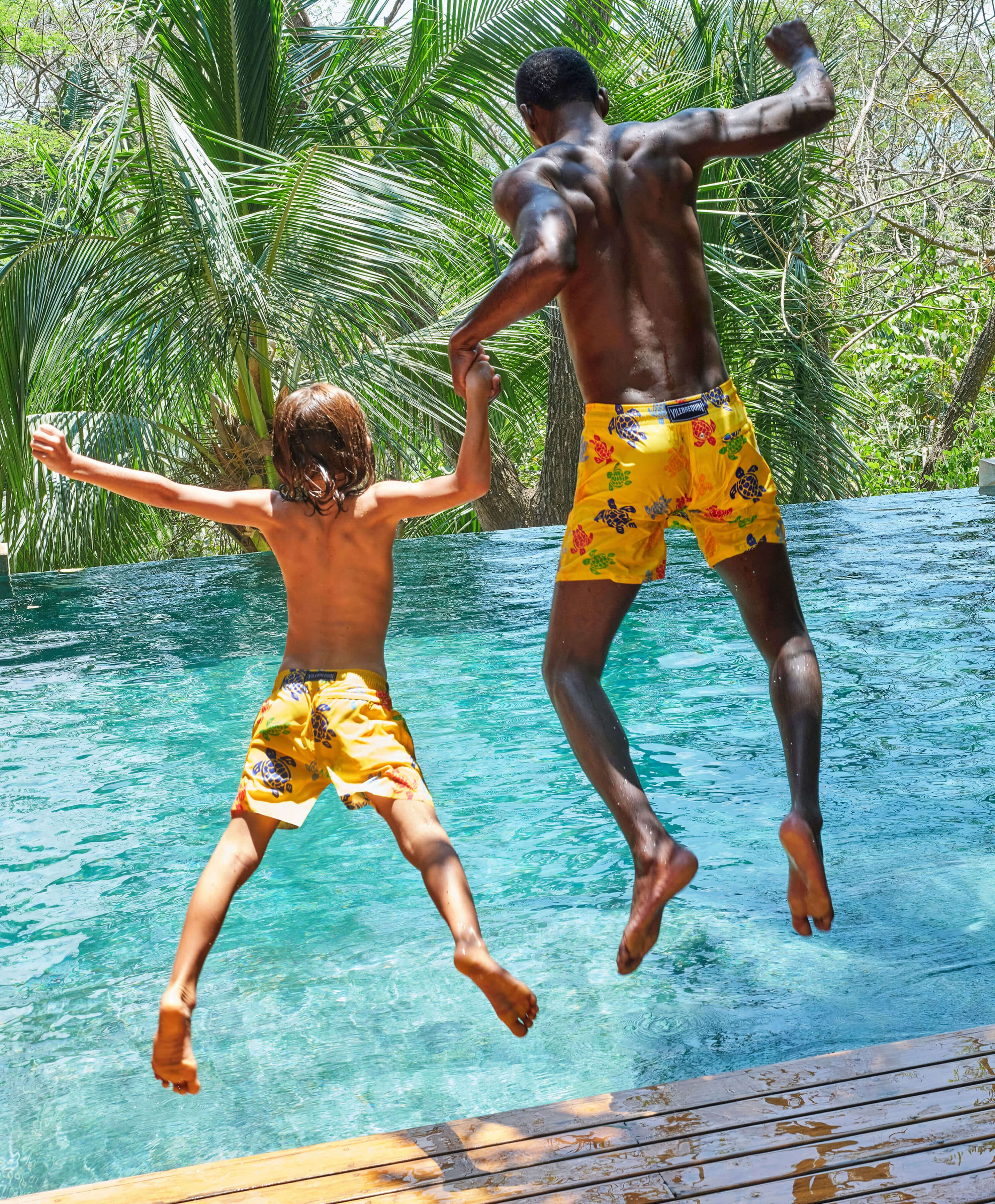 Bañadores ultraligeros para hombre Un padre y su hijo están saltando a una piscina con bañadores a juego.