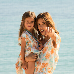Mother and daughter wearing matching beach dresses