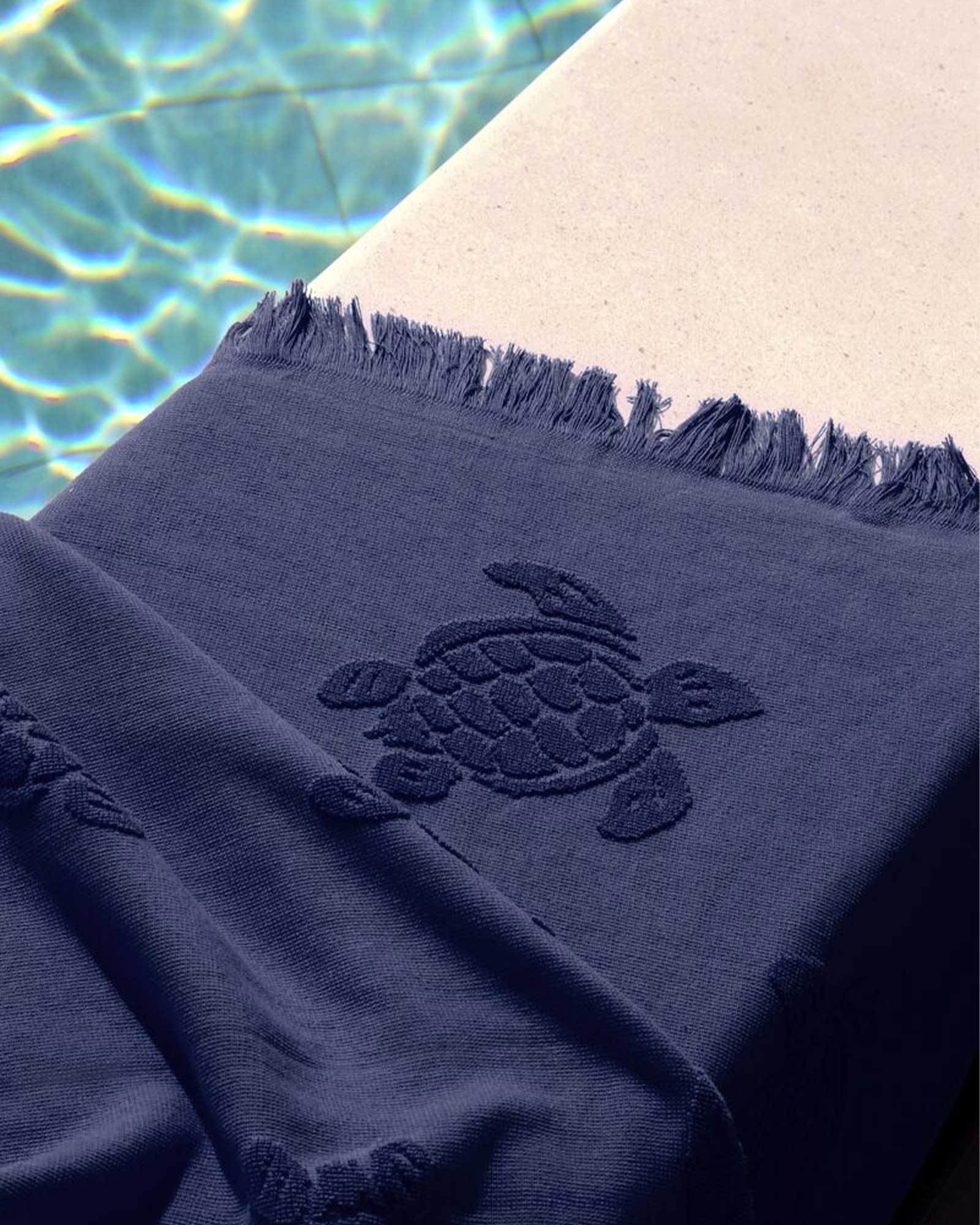 Beach towel next to a swimming pool