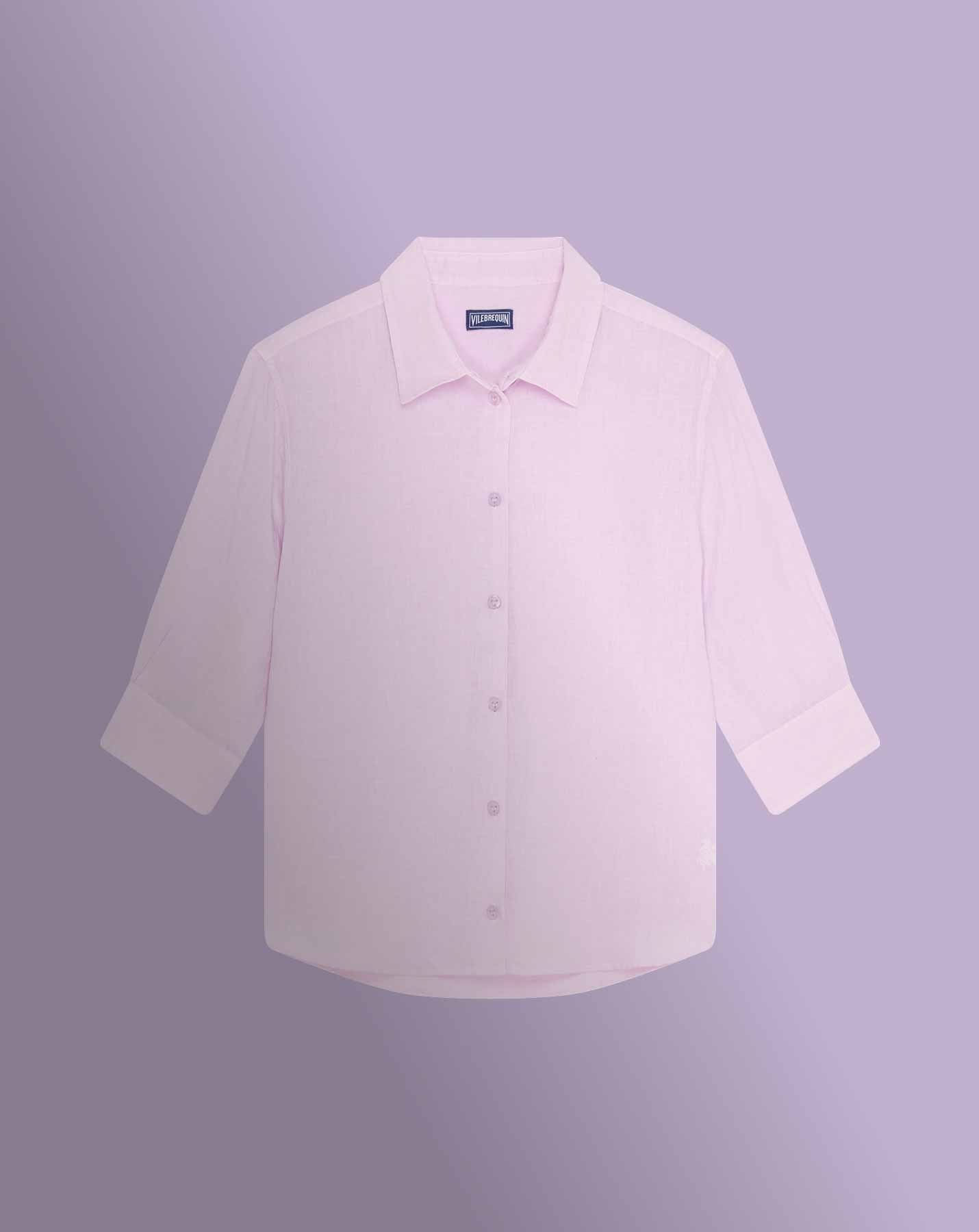 Une autre femme, portant une chemise, marche le long de la plage