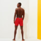 Herren Flat belts Uni - Kurze und figurbetonte Einfarbige Stretch-Badehose für Herren, Mohnrot Rückansicht getragen